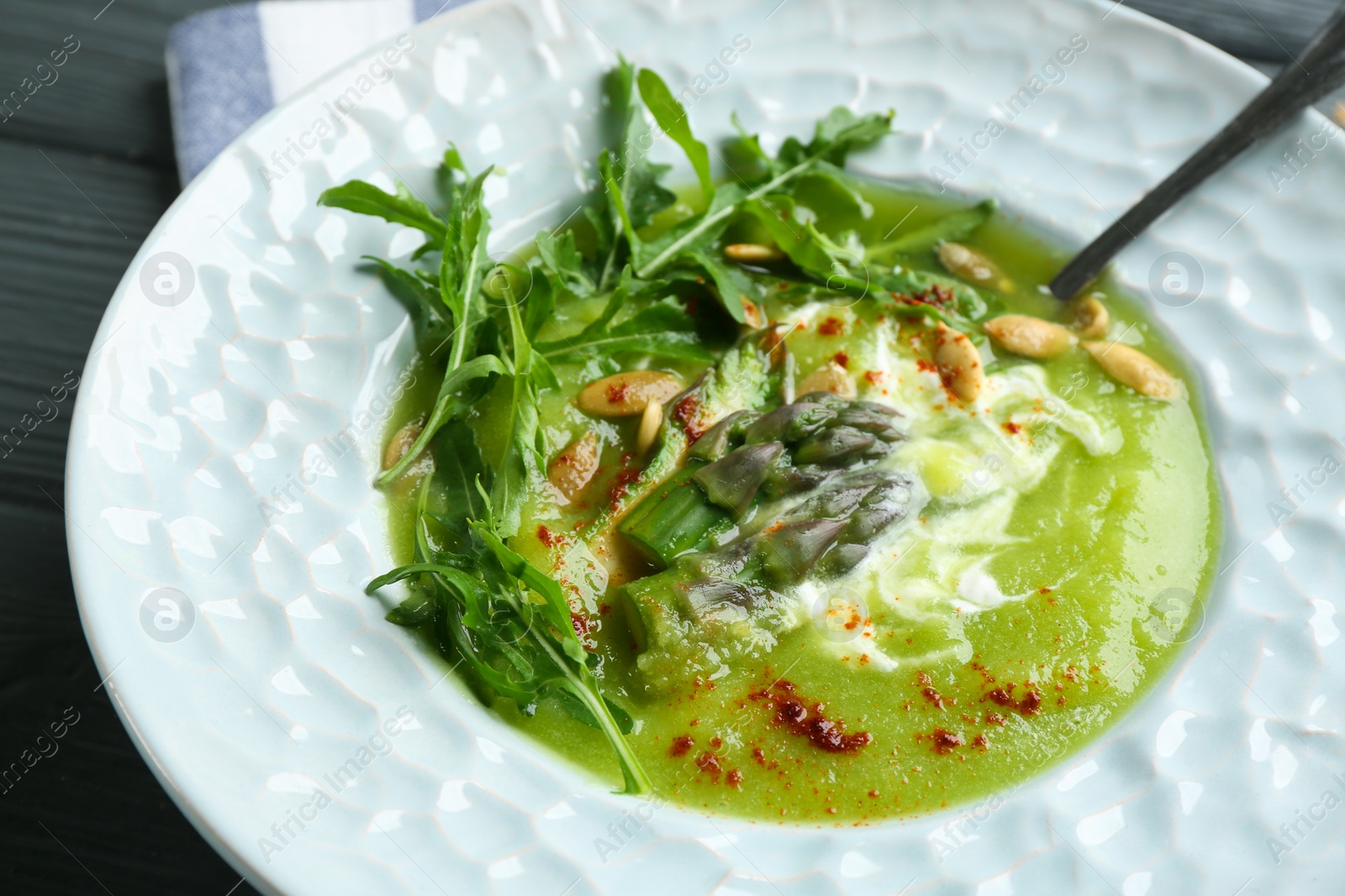 Photo of Delicious asparagus soup served on table, closeup