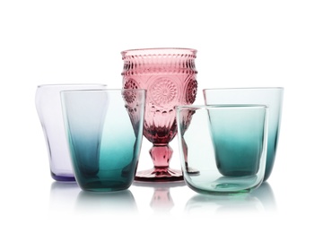 Photo of Set of colorful empty glasses on white background