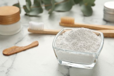 Tooth powder and brushes on white marble table, closeup