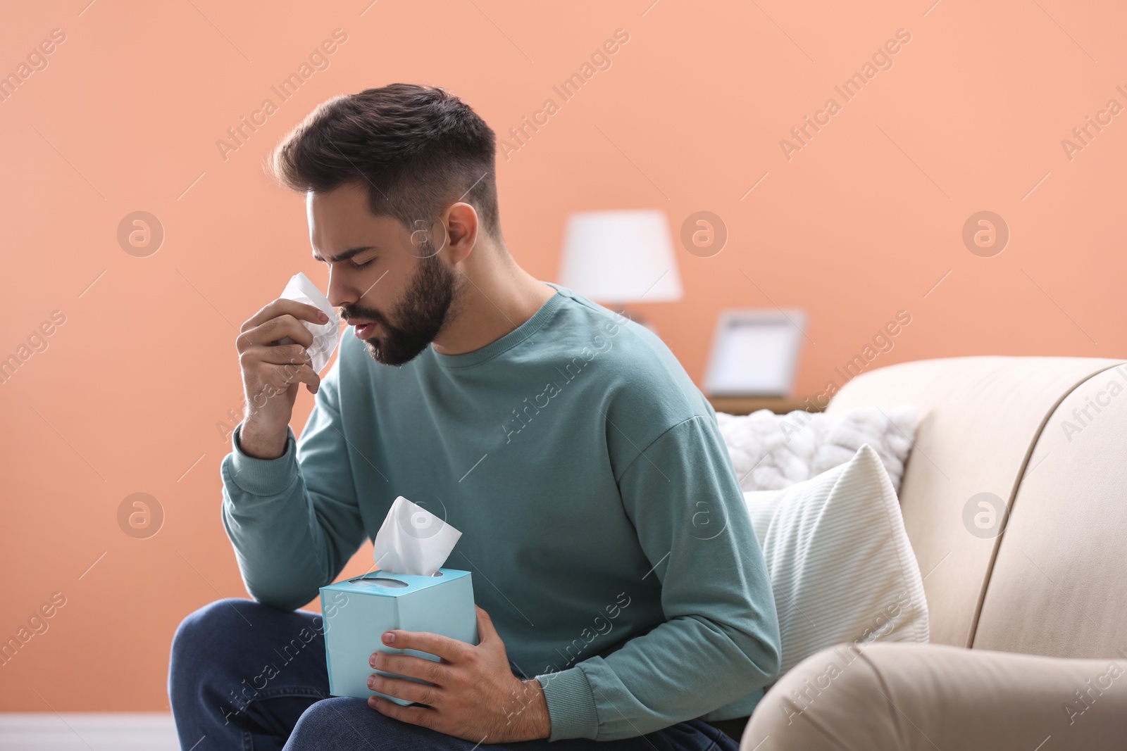 Photo of Man suffering from runny nose at home