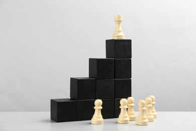 Photo of Chess piece on top of black stairs against light background. Career promotion concept