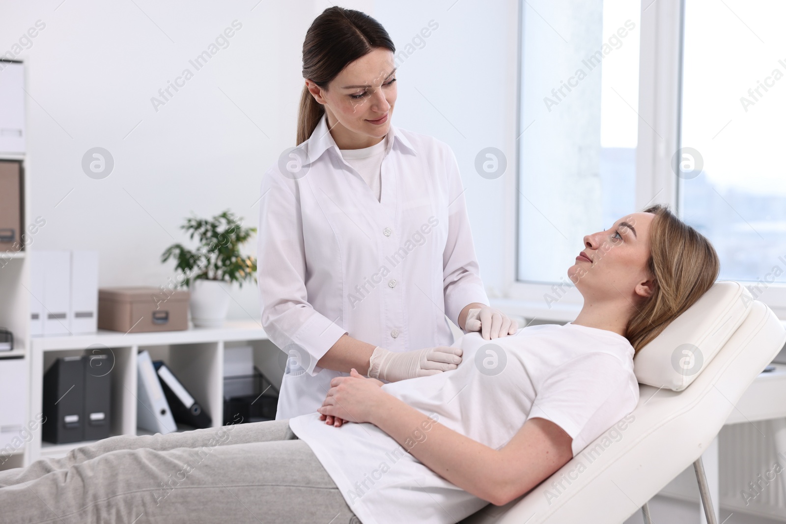 Photo of Mammologist checking young woman's breast in hospital