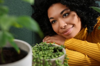 Relaxing atmosphere. Beautiful woman near potted houseplants