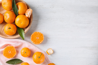 Fresh ripe tangerines on white wooden table, flat lay. Space for text