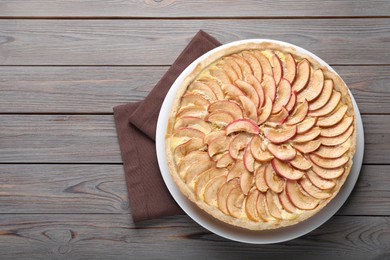 Photo of Freshly baked delicious apple pie on wooden table, top view