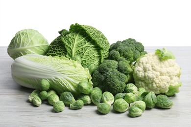 Photo of Many different fresh ripe cabbages on white wooden table