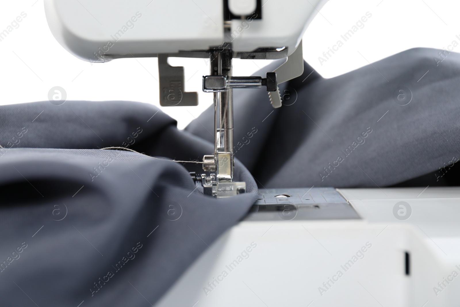 Photo of Sewing machine with grey fabric isolated on white