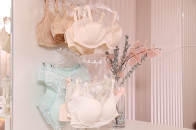 Photo of Luxury women's underwear on hangers in lingerie store