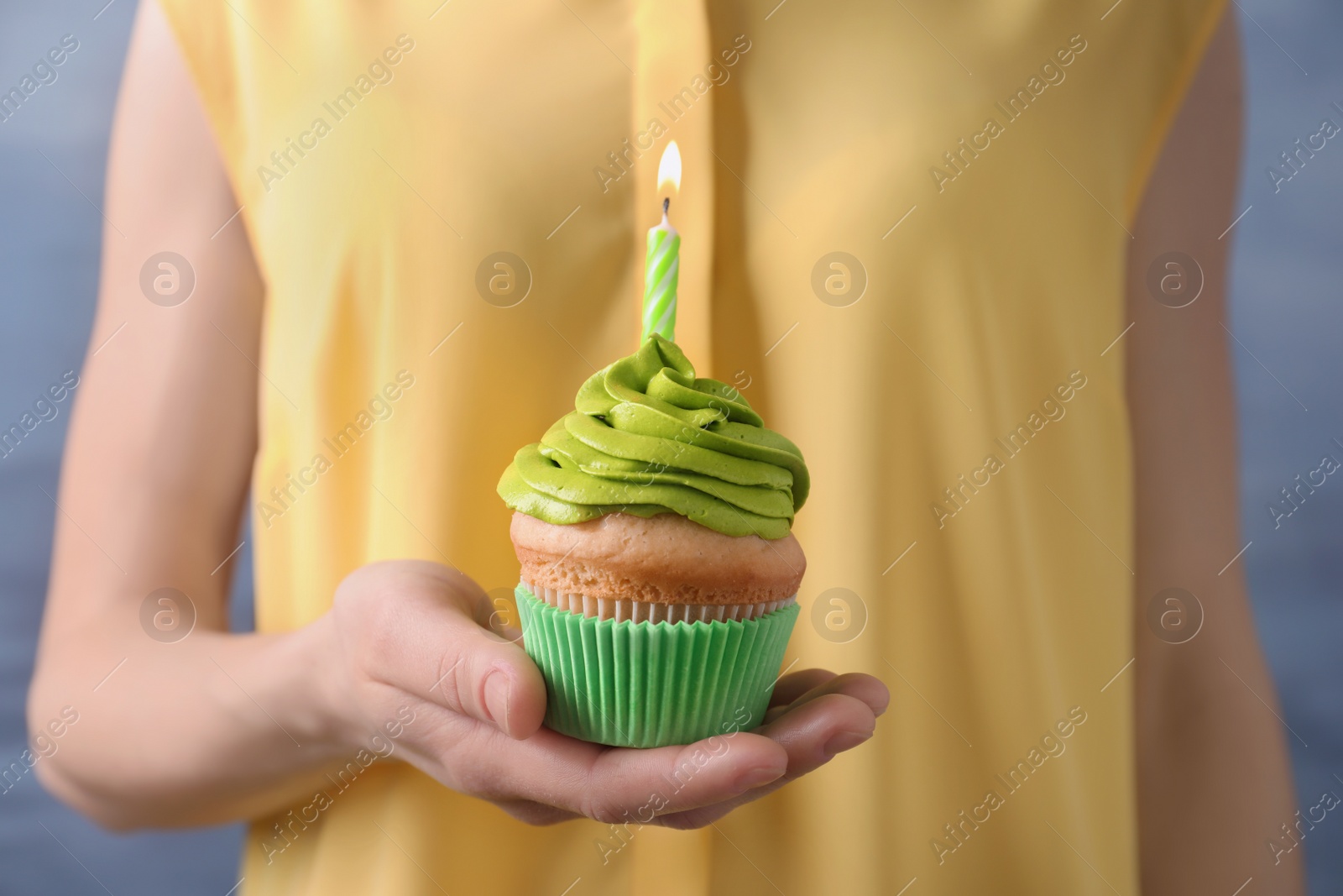 Photo of Woman holding birthday cupcake, closeup