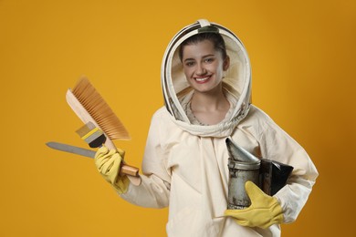 Photo of Beekeeper in uniform with tools on yellow background