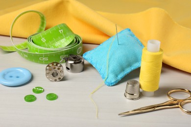 Photo of Set of sewing supplies and accessories on white table