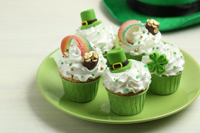 St. Patrick's day party. Tasty festively decorated cupcakes on white table, closeup