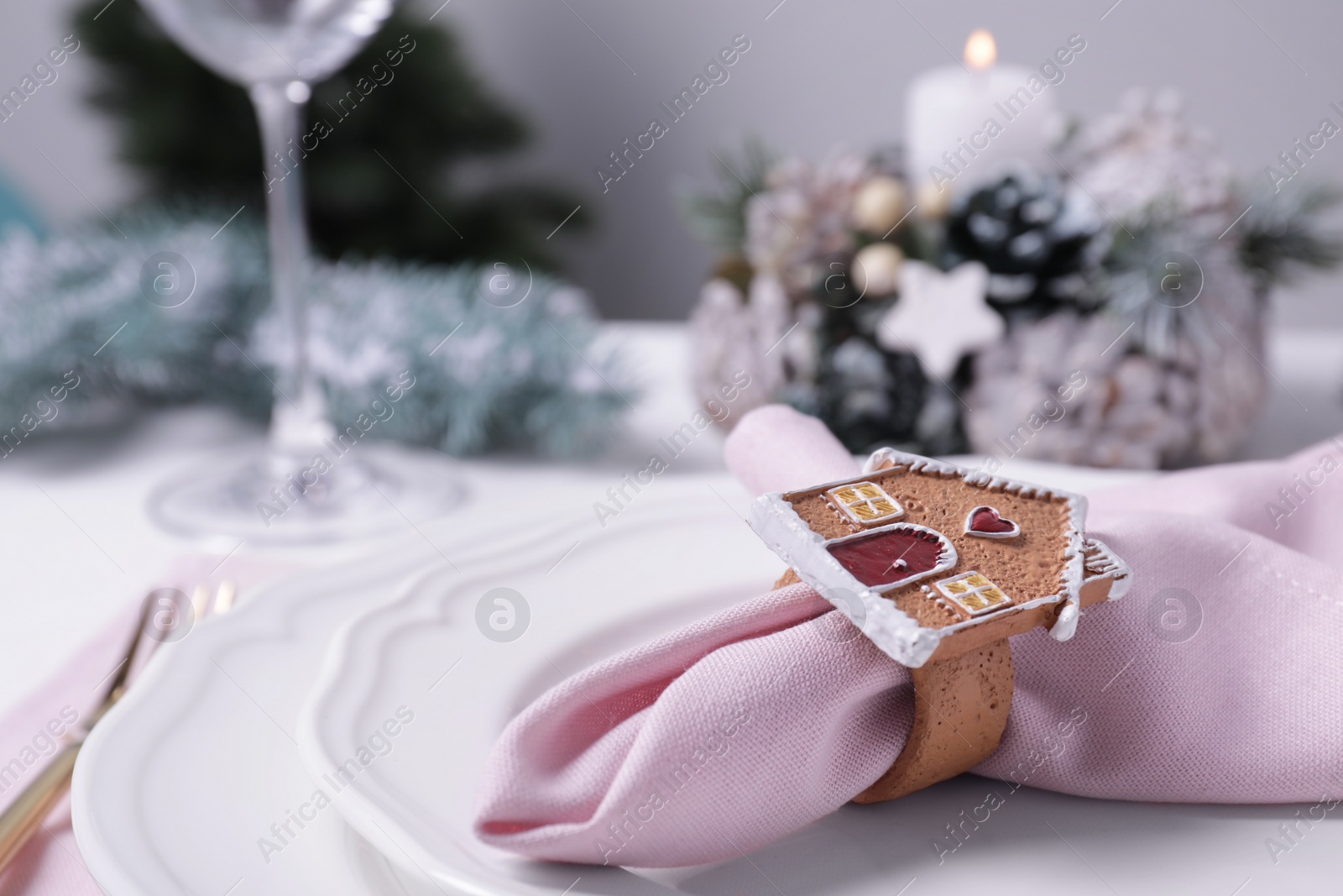 Photo of Pink fabric napkin and beautiful decorative ring on white table, closeup. Space for text