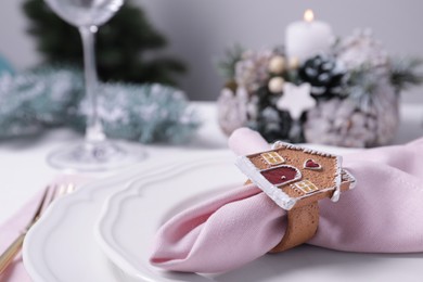 Pink fabric napkin and beautiful decorative ring on white table, closeup. Space for text