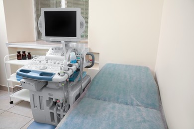 Photo of Ultrasound machine, medical trolley and examination table in hospital