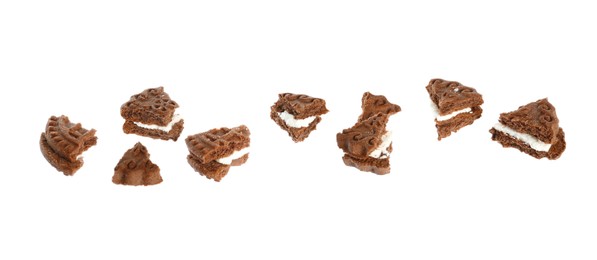 Photo of Pieces of tasty chocolate sandwich cookie with cream on white background