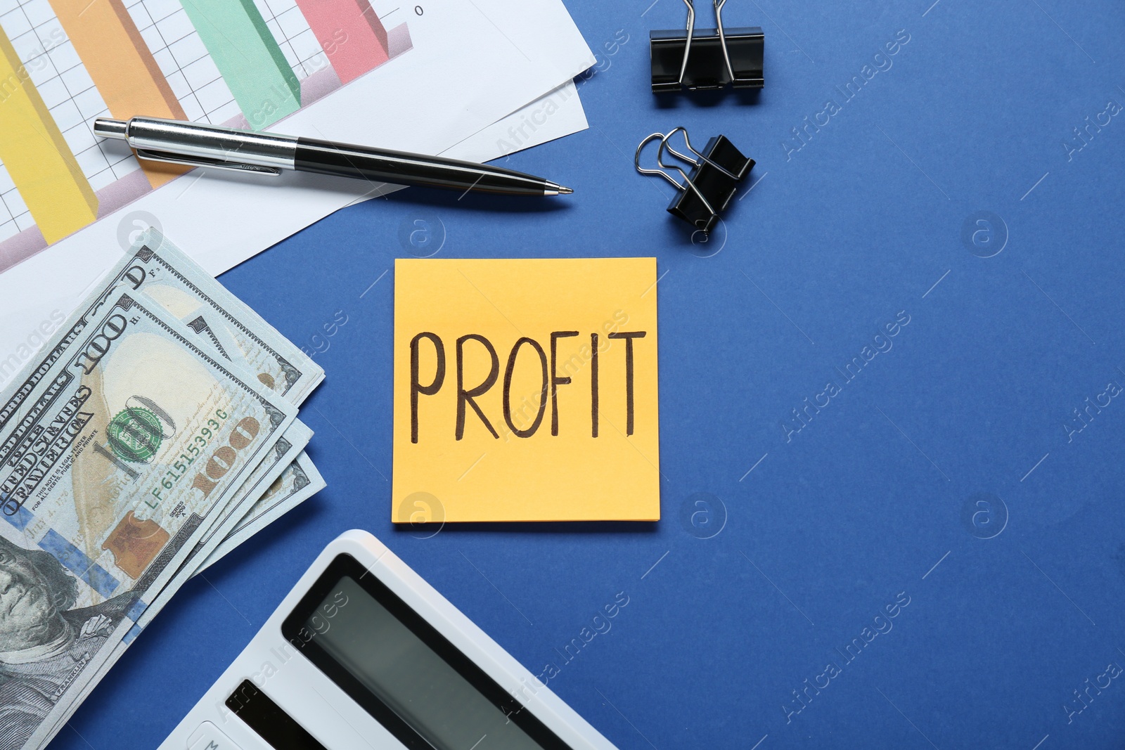 Photo of Sticky note with word Profit, diagram, banknotes and calculator on blue background, flat lay. Space for text