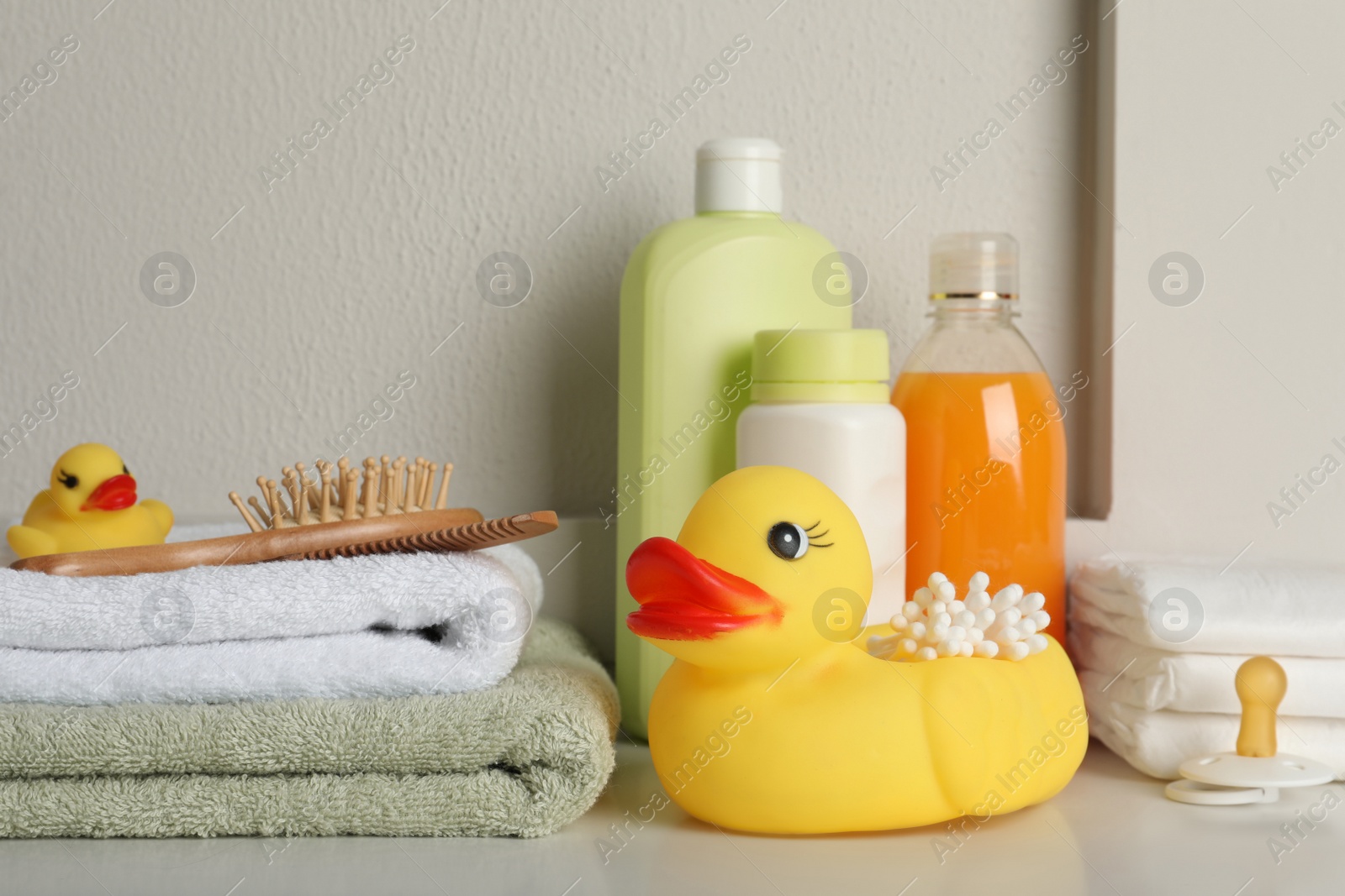 Photo of Bathroom towels, toy and baby accessories on white table