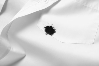 Photo of Stain of black ink on white shirt, closeup