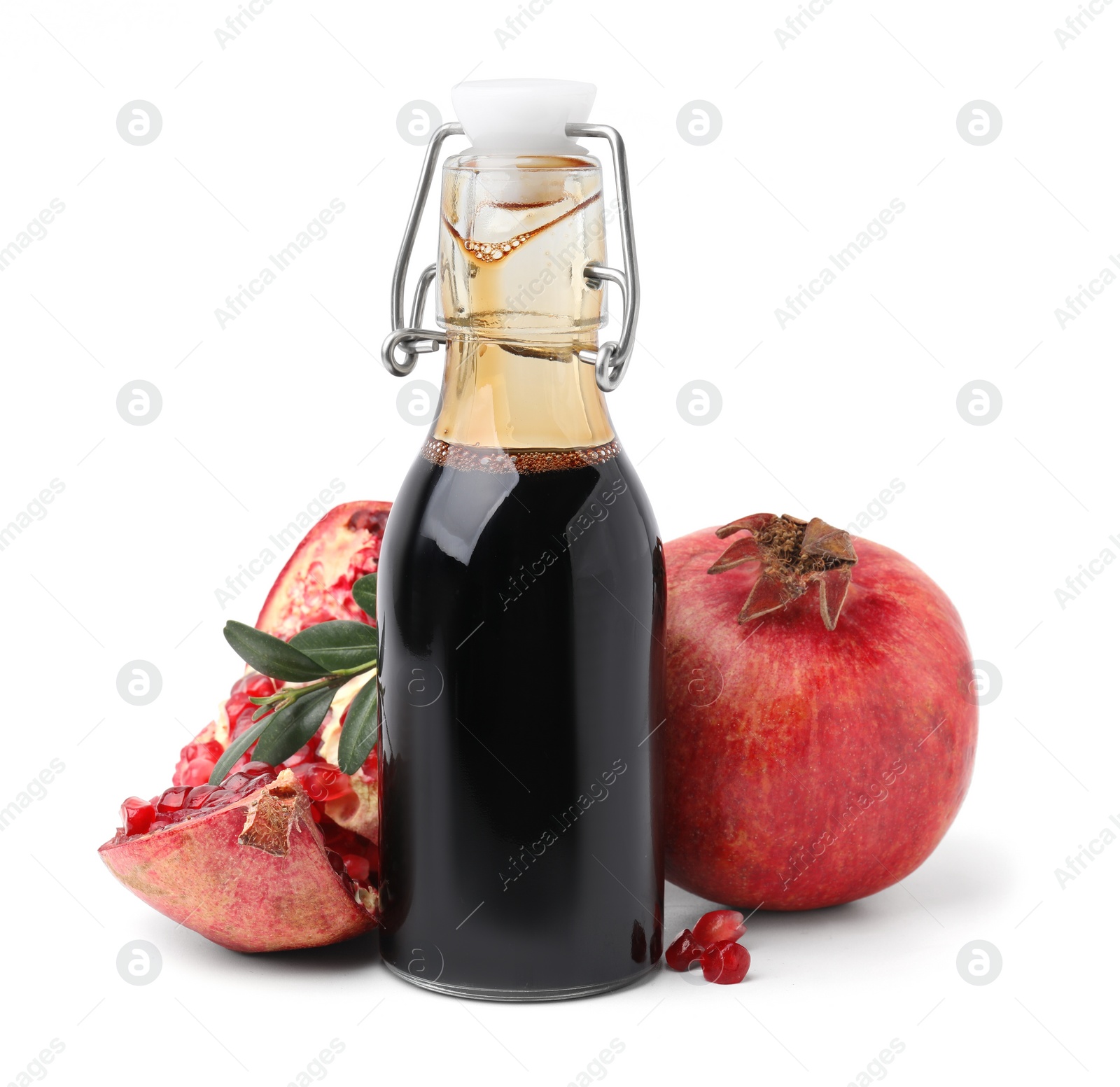 Photo of Tasty pomegranate sauce in bottle, fruits and branch isolated on white