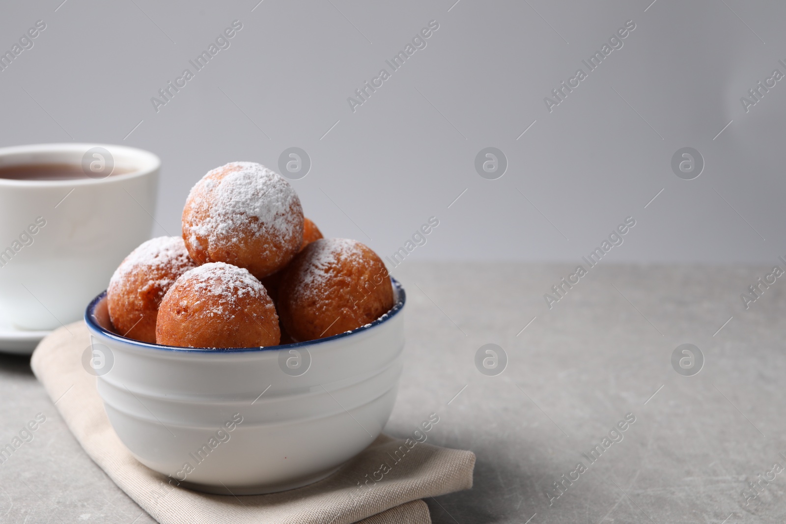 Photo of Delicious sweet buns in bowl on gray table, space for text