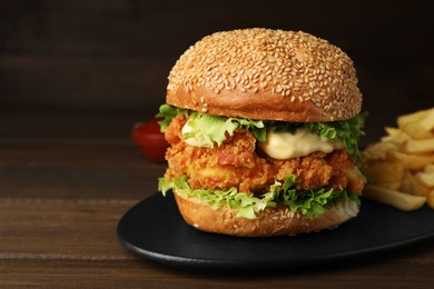 Photo of Delicious burger with crispy chicken patty on wooden table, closeup. Space for text