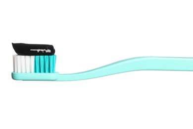 Photo of Brush with charcoal toothpaste against white background