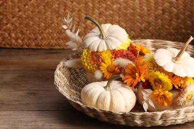 Photo of Composition with small pumpkins, beautiful flowers and spikelets on wooden table. Space for text