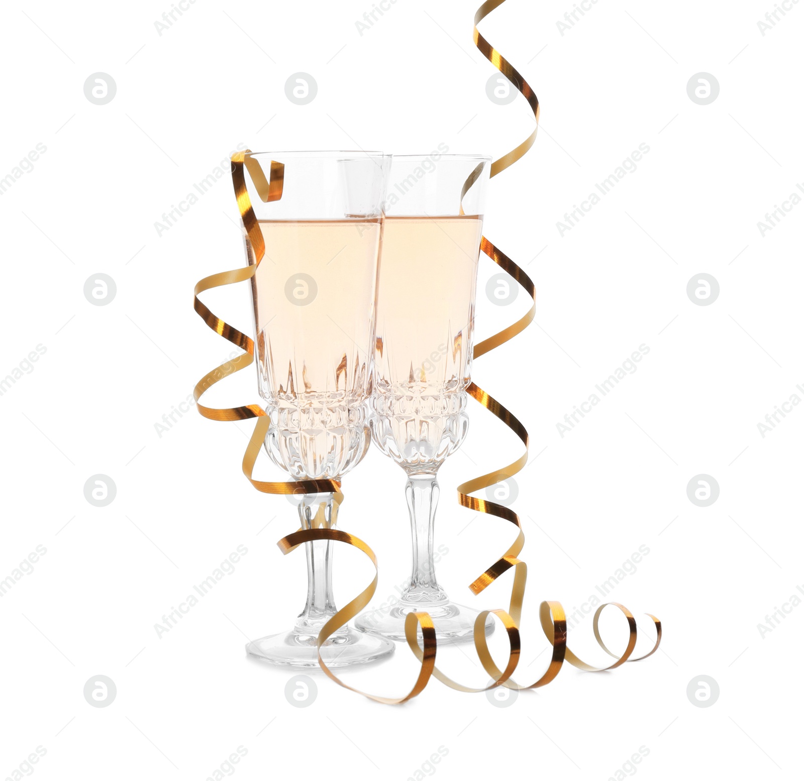 Photo of Glasses of rose champagne and streamers on white background