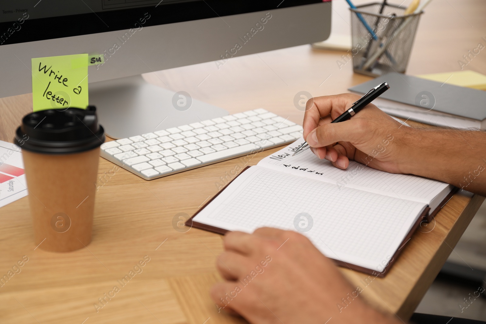 Photo of Man planning his schedule at table in office, closeup