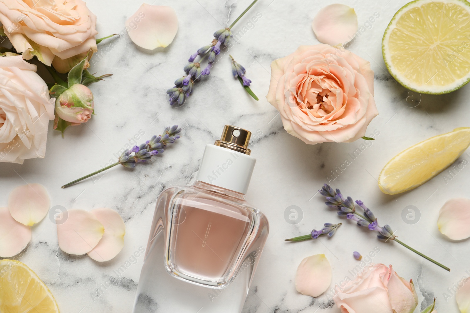 Photo of Flat lay composition with bottle of perfume and fresh citrus fruits on white marble table