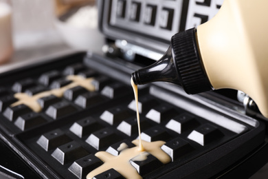 Photo of Pouring dough onto Belgian waffle maker, closeup