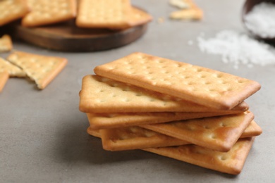 Stack of delicious crackers on grey table, closeup