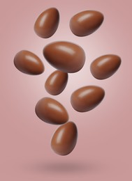 Image of Many chocolate eggs falling on dusty pink background