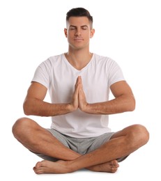 Handsome man meditating on white background. Harmony and zen