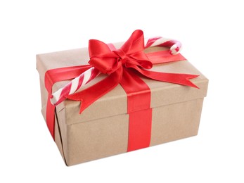 Image of Christmas gift box decorated with red bow and candy cane on white background