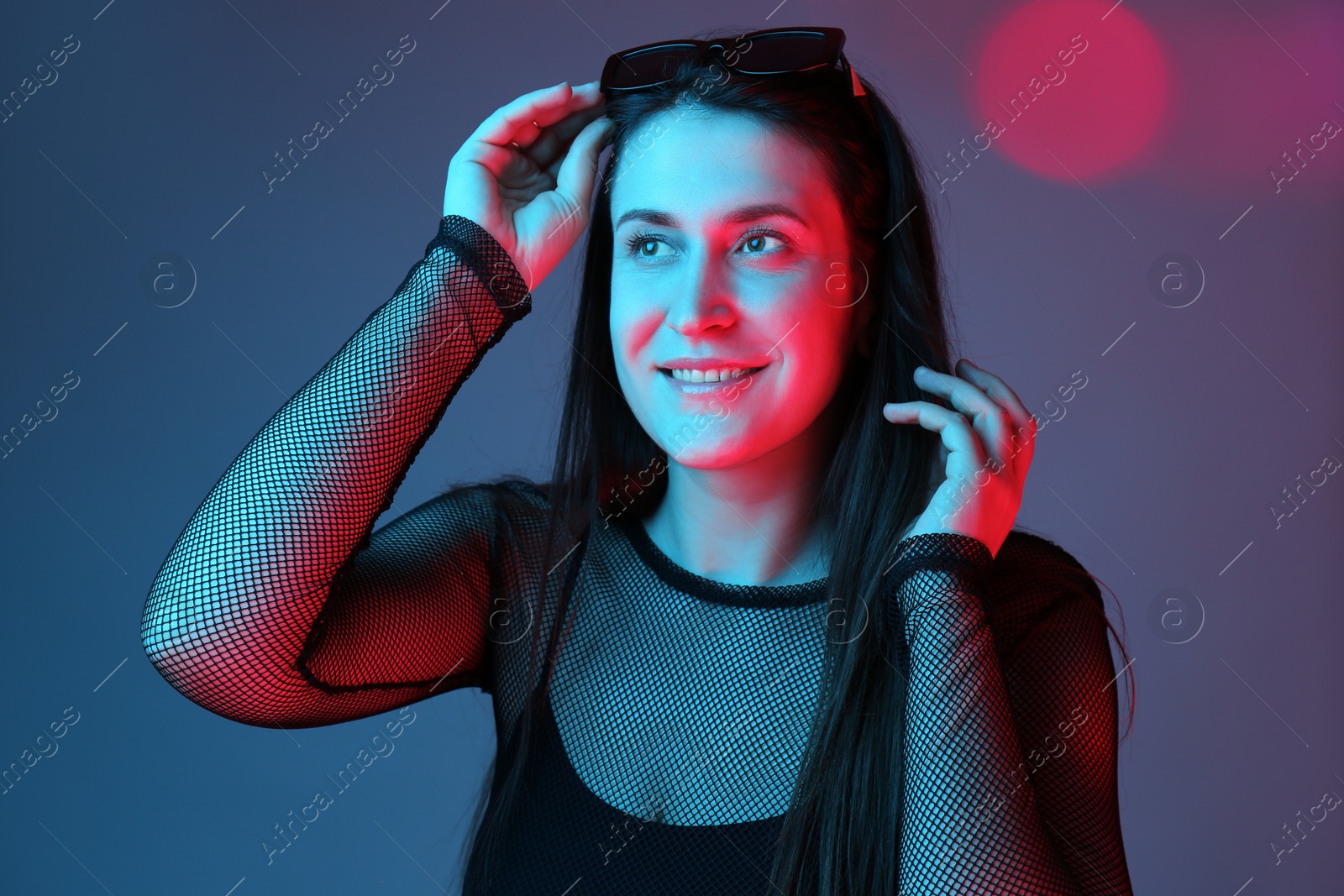 Photo of Portrait of beautiful young woman with sunglasses on color background