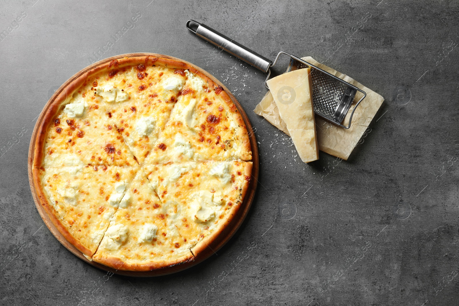 Photo of Tasty hot pizza, cheese and grater on grey background, top view