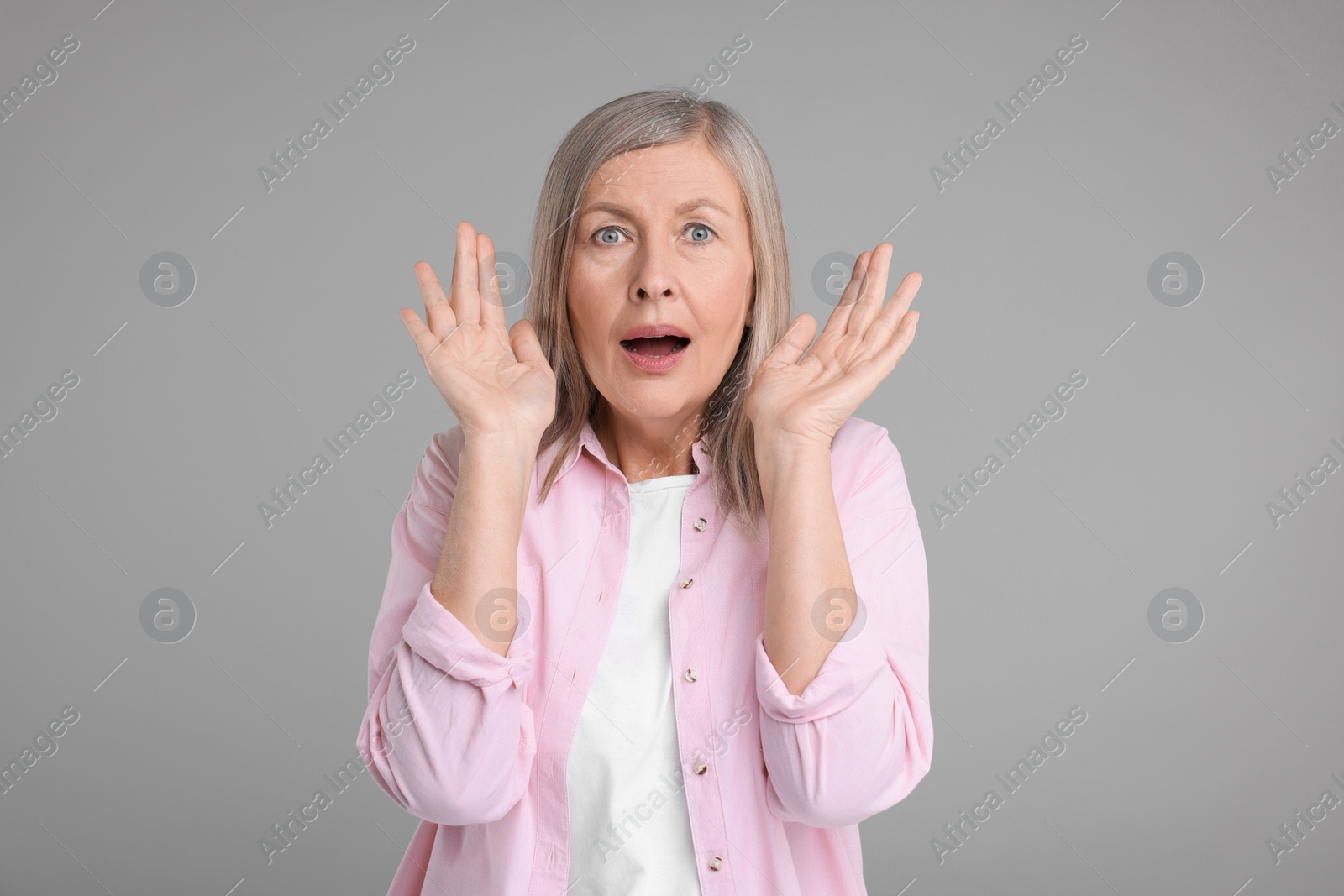 Photo of Portrait of surprised senior woman on grey background