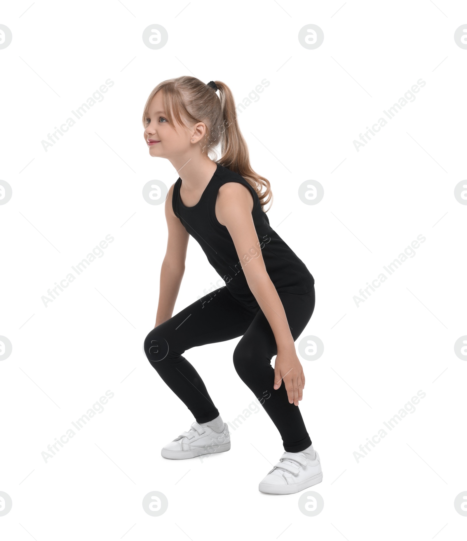 Photo of Little girl doing squats on white background. Morning exercise