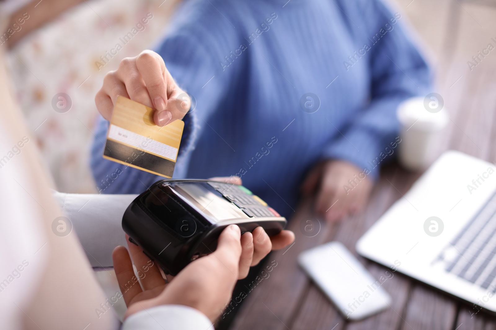 Photo of Woman with credit card using payment terminal at restaurant, closeup