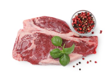 Photo of Piece of fresh beef meat with basil leaves and spices isolated on white, top view