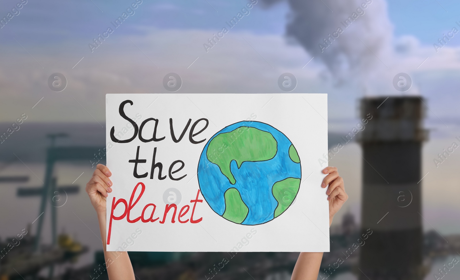 Image of Protestor holding placard with text Save The Planet and blurred view of industrial factory on background. Climate strike