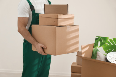 Photo of Man with cardboard boxes in room, closeup. Moving service