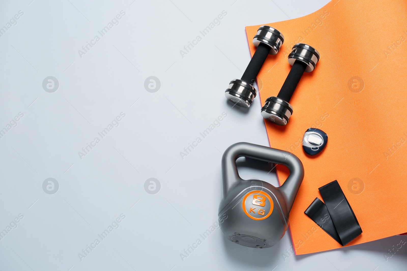 Photo of Exercise mat and other sport equipment on white background, flat lay. Space for text