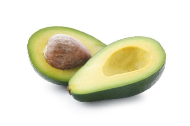 Photo of Halves of ripe avocado with pit on white background