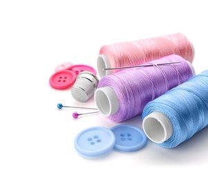 Photo of Color threads and sewing accessories on white background