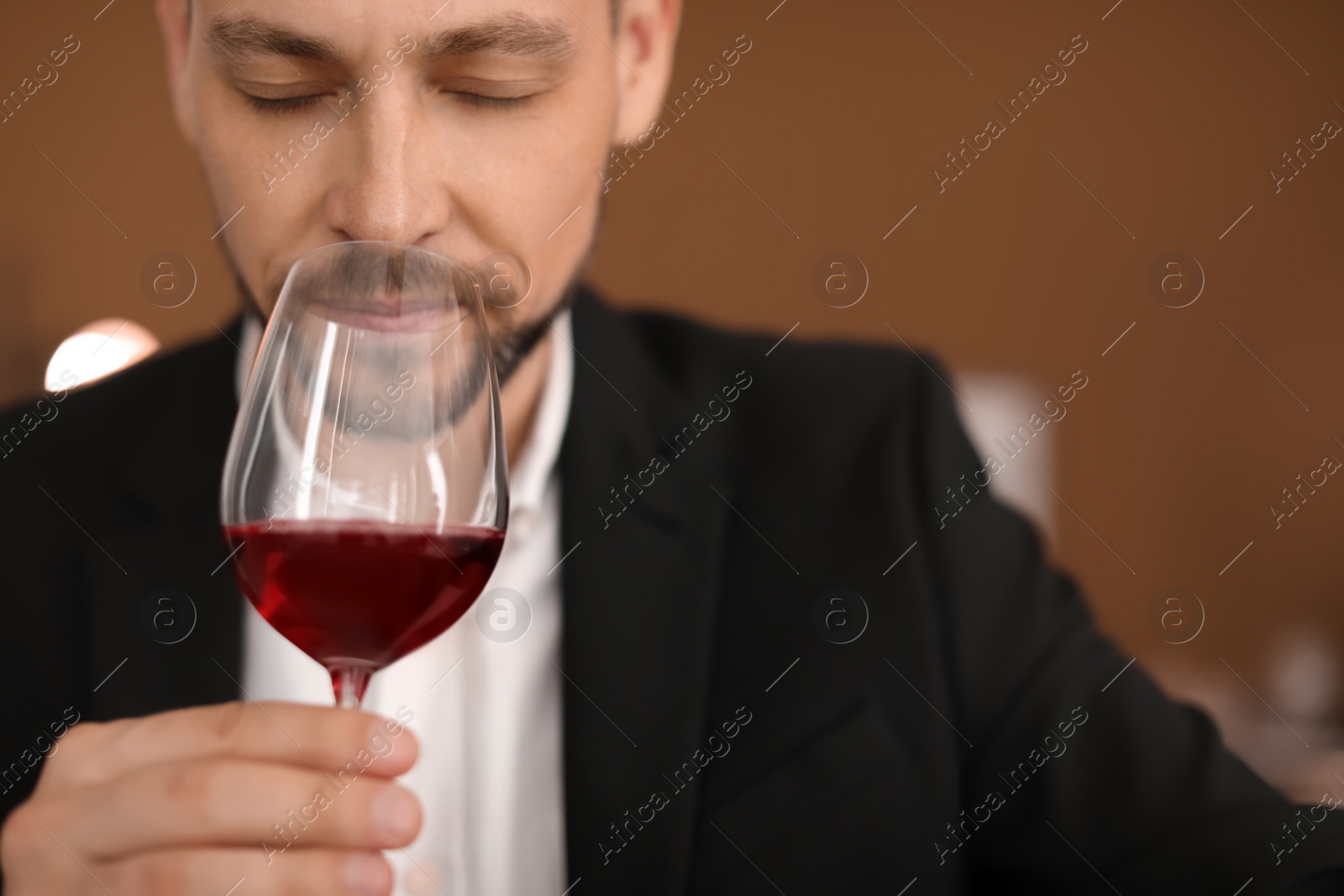 Photo of Young man with glass of wine indoors