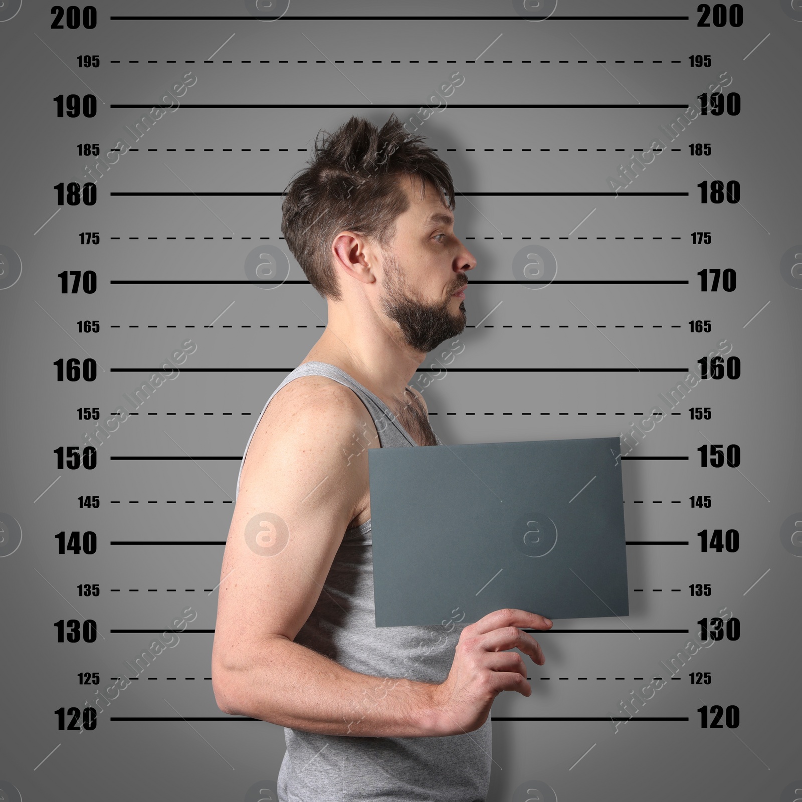 Image of Criminal mugshot. Arrested man with blank card against height chart