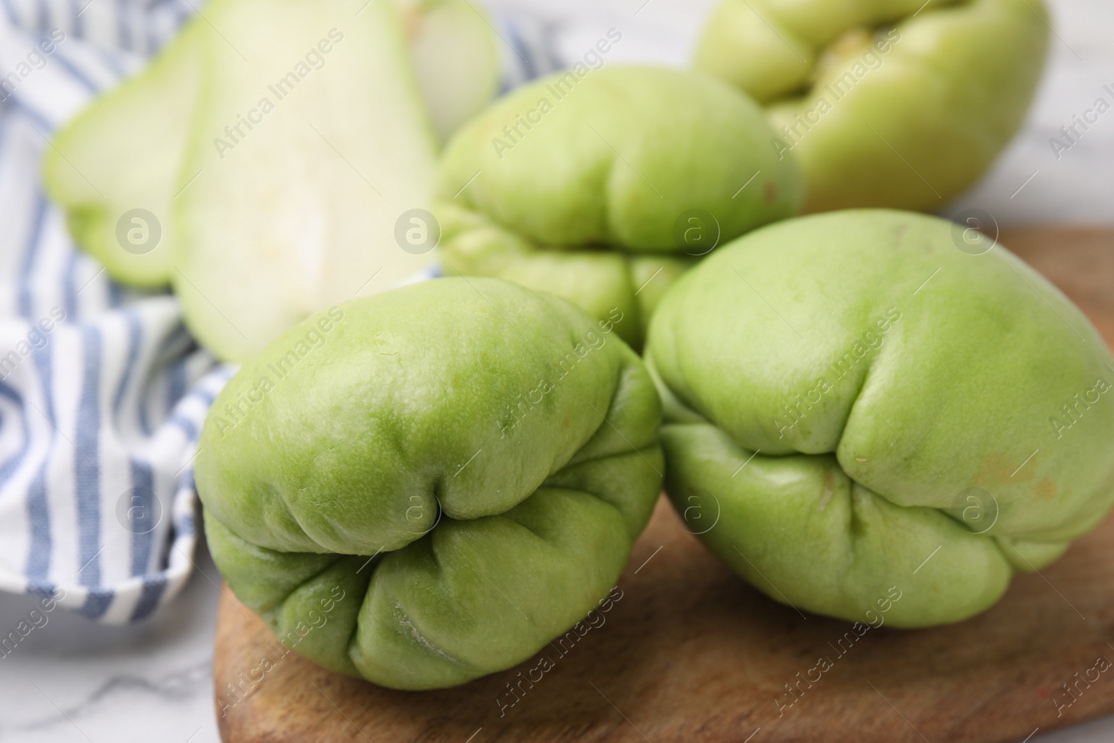 Photo of Many fresh green chayote on table, closeup